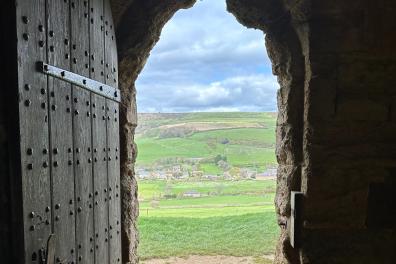 wooden and stone door with landscape behind.png